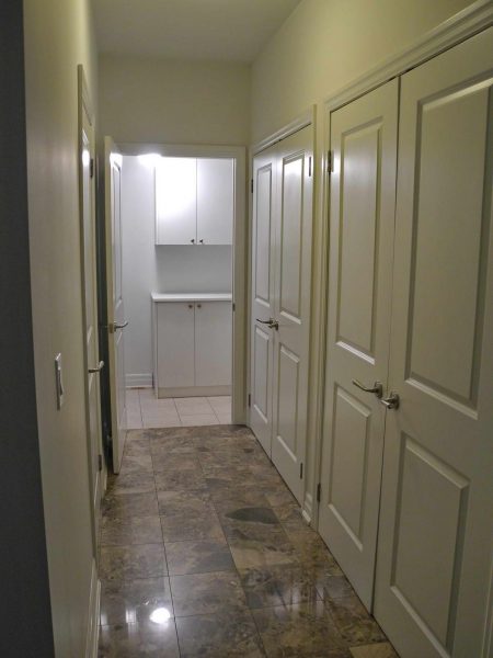 The hall to the laundry room has closets and the powder room